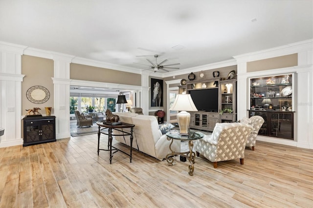4515 Biggs Pl, The Villages, FL 32163 - living area with crown molding, ceiling fan, decorative columns, and wood finished floors