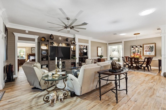 4515 Biggs Pl, The Villages, FL 32163 - living area with crown molding, decorative columns, light wood finished floors, and ceiling fan with notable chandelier