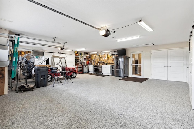 4515 Biggs Pl, The Villages, FL 32163 - garage with freestanding refrigerator, a workshop area, and a garage door opener
