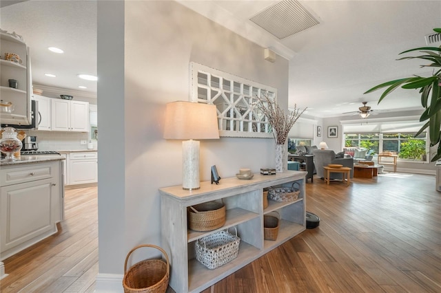 interior space with crown molding and light hardwood / wood-style floors