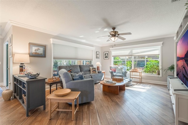 living room with crown molding, ceiling fan, hardwood / wood-style flooring, and a textured ceiling