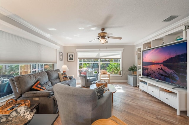 living room featuring crown molding, ceiling fan, a textured ceiling, and light hardwood / wood-style floors