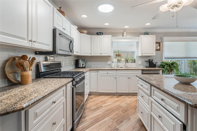 kitchen featuring white cabinetry, stainless steel appliances, light stone countertops, and sink