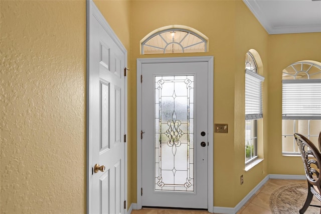 foyer with baseboards, light tile patterned floors, and crown molding