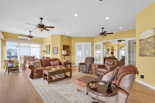 living room featuring baseboards, french doors, light wood-type flooring, and recessed lighting