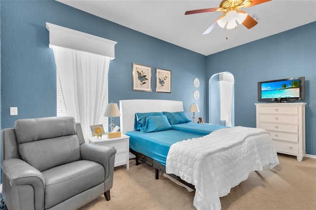 bedroom featuring baseboards, a ceiling fan, and light colored carpet