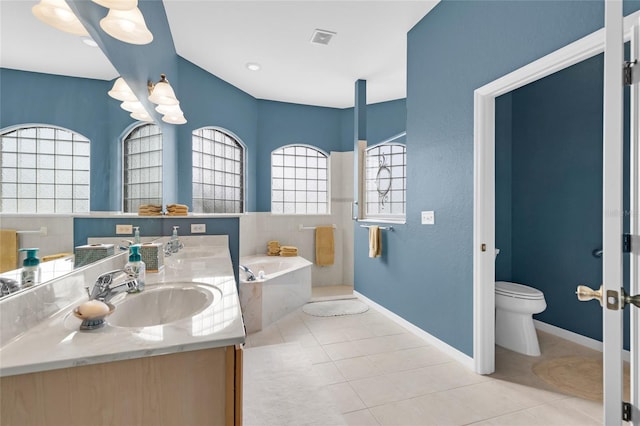 bathroom featuring toilet, tile patterned floors, a sink, and a bath