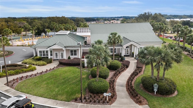 view of front of house featuring metal roof, french doors, a standing seam roof, and a front yard