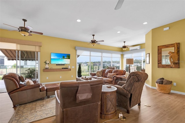 living area featuring light wood finished floors, baseboards, an AC wall unit, and recessed lighting