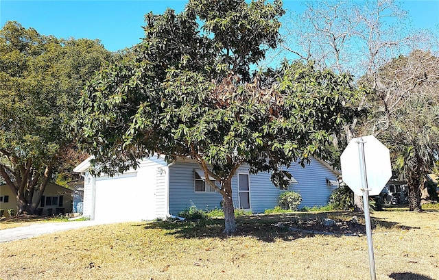 view of side of property with a garage and a lawn