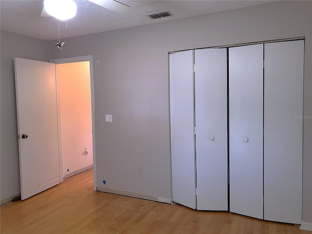 unfurnished bedroom with ceiling fan, light hardwood / wood-style floors, and a textured ceiling