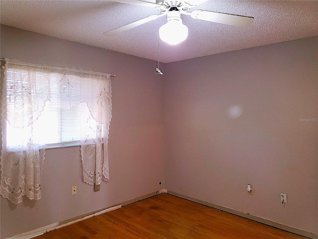 spare room with wood-type flooring, ceiling fan, and a textured ceiling