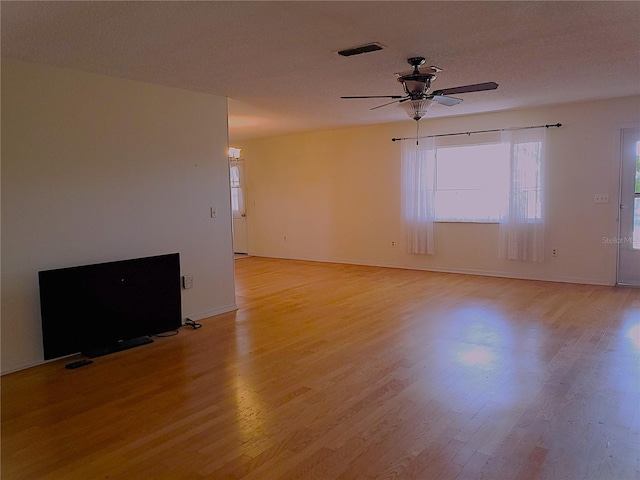 empty room featuring ceiling fan, a textured ceiling, and light wood-type flooring