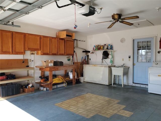 garage featuring a garage door opener, washer / clothes dryer, sink, and a workshop area