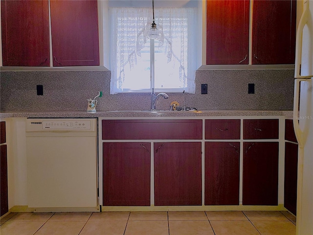 kitchen with light tile patterned flooring, white appliances, decorative light fixtures, and sink