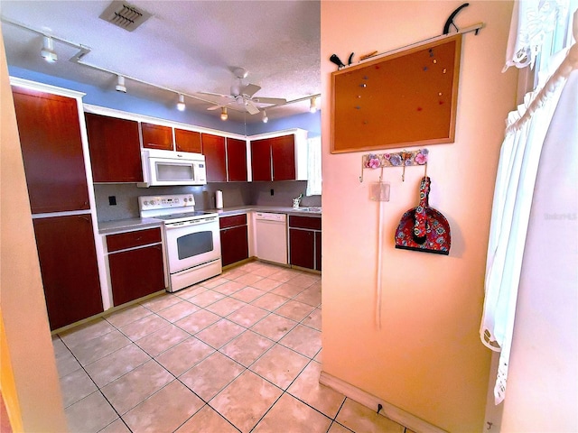 kitchen featuring light tile patterned flooring, sink, white appliances, ceiling fan, and a textured ceiling