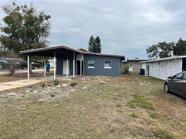 manufactured / mobile home with a front lawn and a carport