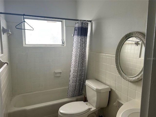 bathroom with tile walls, shower / bathtub combination with curtain, and toilet