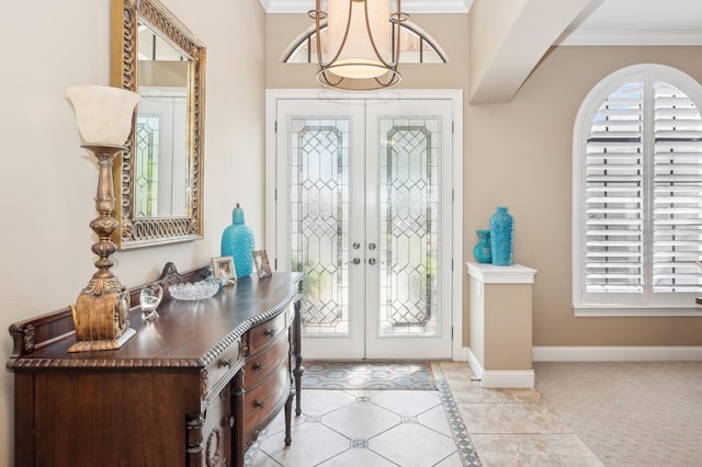 entryway with crown molding, light tile patterned flooring, and french doors