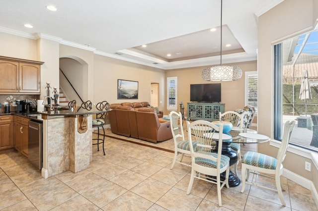 kitchen featuring a breakfast bar, sink, hanging light fixtures, a tray ceiling, and dishwasher