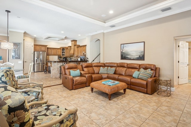 tiled living room with ornamental molding and a tray ceiling