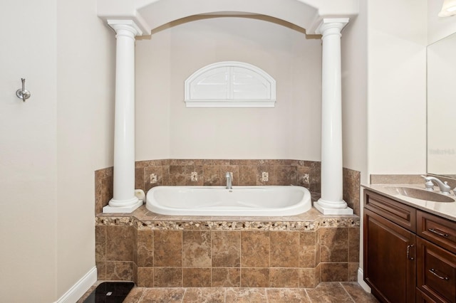 bathroom featuring tiled bath and ornate columns