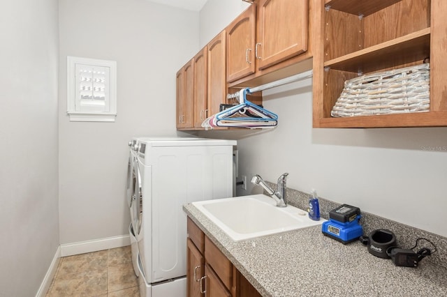 clothes washing area featuring cabinets, sink, washer and dryer, and light tile patterned floors