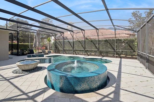 view of pool featuring an in ground hot tub, a patio area, and glass enclosure