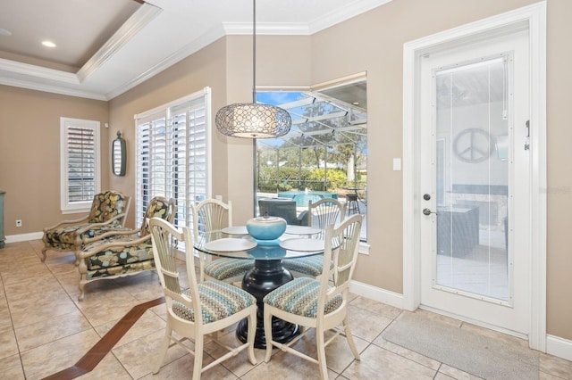 tiled dining space with crown molding and a tray ceiling