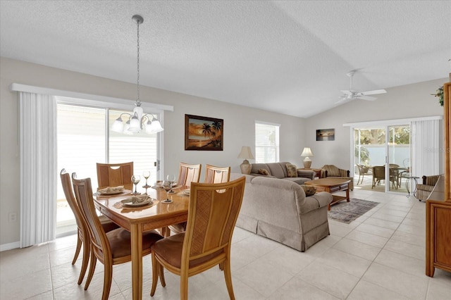 dining area with a healthy amount of sunlight, vaulted ceiling, a textured ceiling, and light tile patterned floors