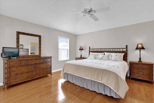 bedroom featuring ceiling fan, a textured ceiling, and light wood-type flooring