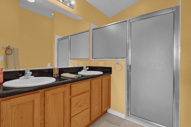 bathroom featuring tile patterned flooring, vanity, a shower with shower door, and lofted ceiling