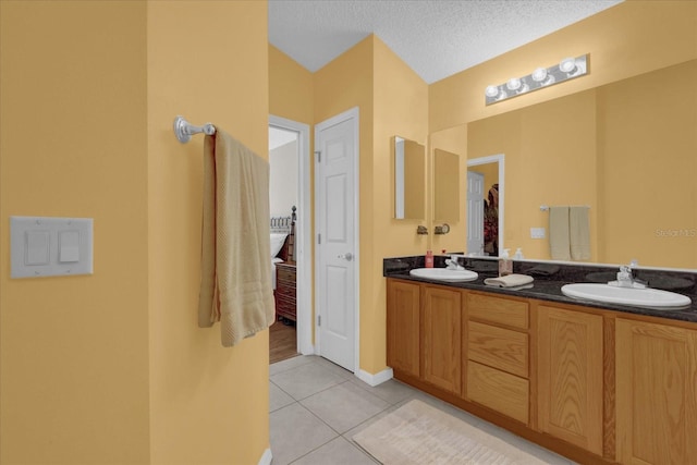 bathroom featuring vanity, tile patterned floors, and a textured ceiling