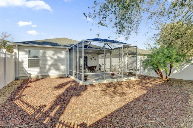 rear view of property with a lanai and a patio area