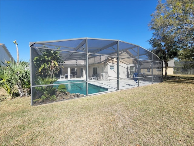 view of pool featuring a patio area, a lawn, and glass enclosure