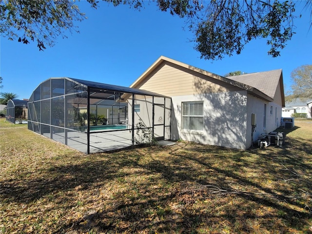 rear view of property with a yard, a lanai, and a patio area