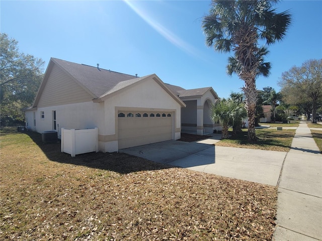 view of property exterior featuring a garage, central AC, and a lawn