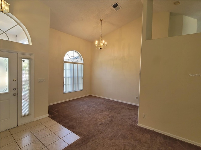 entrance foyer with a textured ceiling, high vaulted ceiling, a chandelier, and carpet flooring