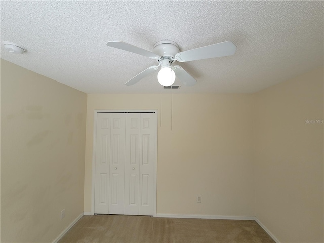 unfurnished bedroom with light colored carpet, a closet, and a textured ceiling