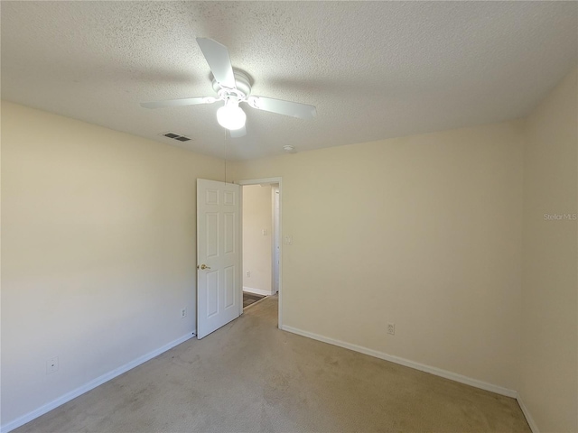 unfurnished room with light carpet, ceiling fan, and a textured ceiling