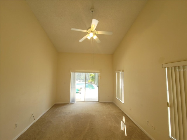 spare room featuring high vaulted ceiling, light colored carpet, and ceiling fan