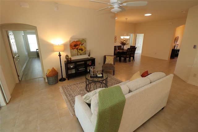 living room featuring light tile patterned flooring and ceiling fan with notable chandelier