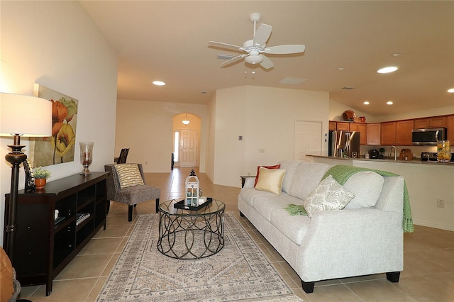 living room featuring ceiling fan, sink, and light tile patterned floors