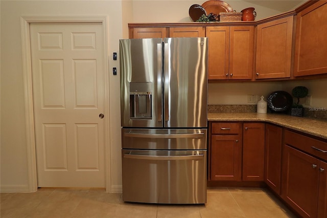 kitchen featuring stainless steel refrigerator with ice dispenser and light tile patterned floors