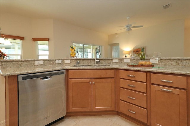 kitchen with sink, light stone countertops, dishwasher, and light tile patterned flooring