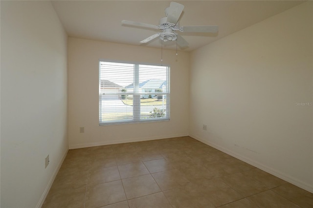 tiled spare room featuring ceiling fan