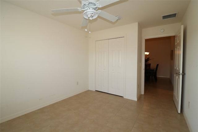 unfurnished bedroom featuring ceiling fan, a closet, and light tile patterned floors