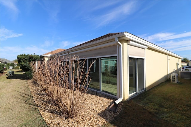 view of property exterior with cooling unit and a lawn