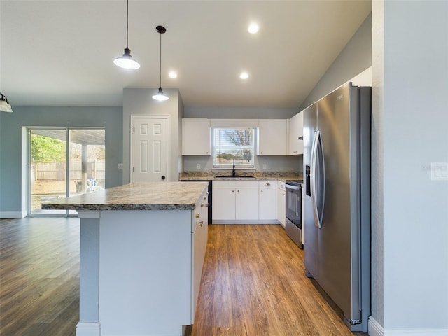 kitchen featuring a kitchen island, hardwood / wood-style floors, pendant lighting, white cabinetry, and stainless steel appliances