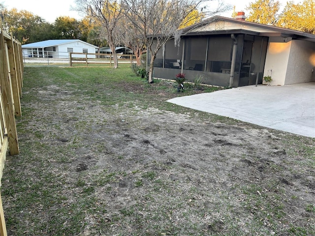 view of yard with a sunroom, a patio area, and fence